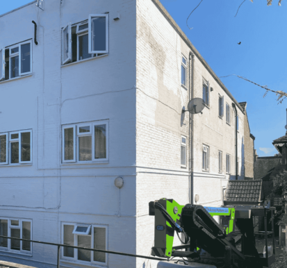 Midway through the project: contrast visible between untreated areas and sections already coated in durable masonry paint.