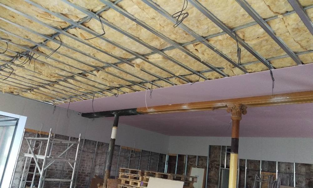 Exposed loft insulation installed beneath roof joists in residential property.