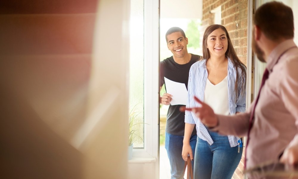 Letting agent showing new tenants around a modernised living space.