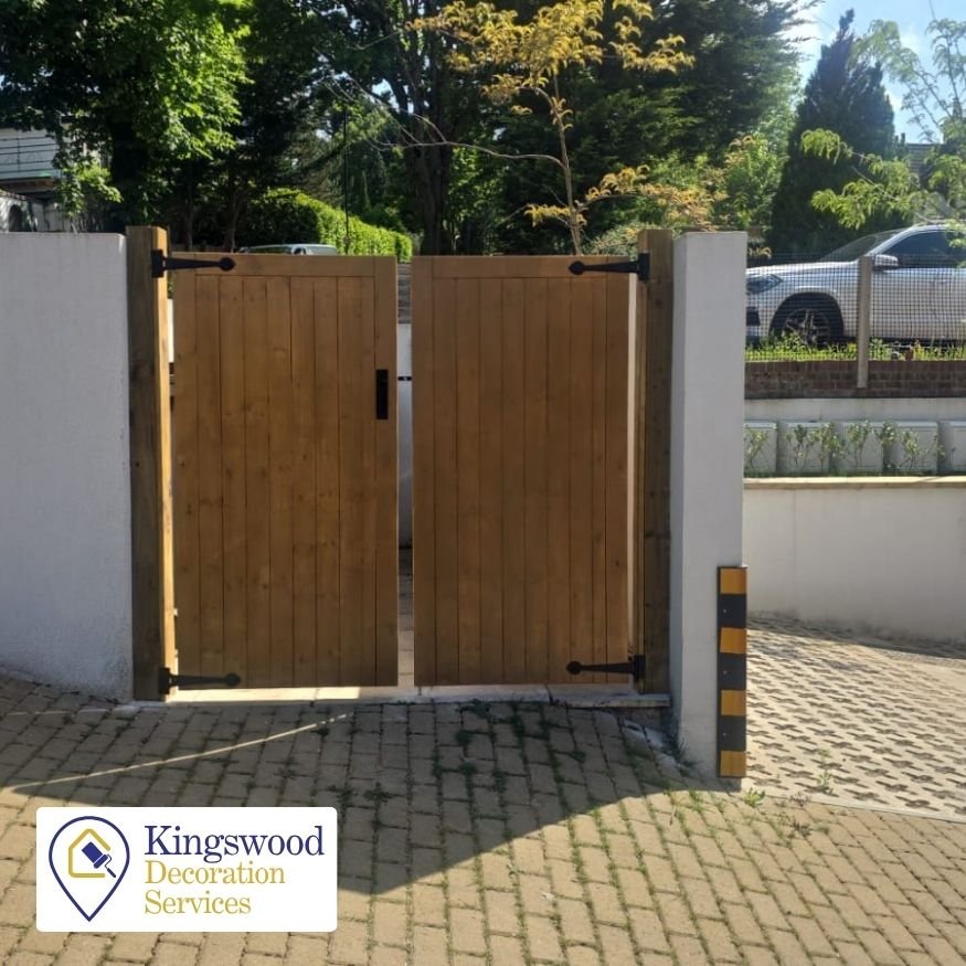 Northamptonshire Gate Fitting Project After- The completed double gate stands securely between two rendered boundary walls, providing privacy and functional enclosure. The warm timber tones and symmetrical hanging deliver a clean, polished finish.