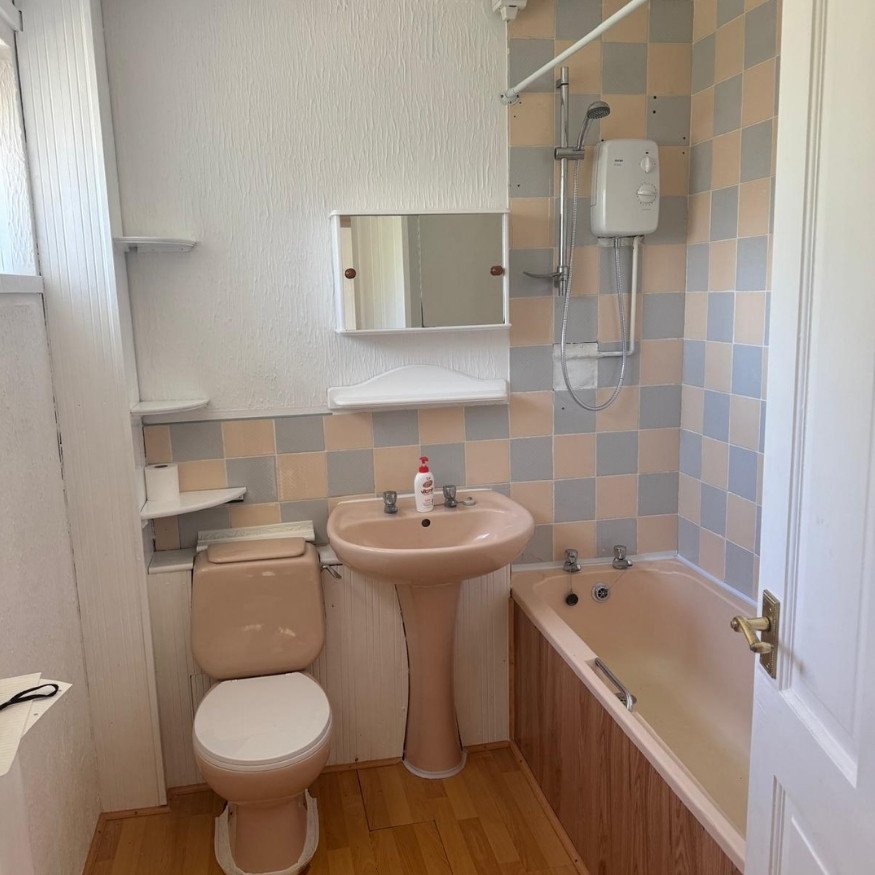 Image 1 (Before)
A dated bathroom suite with peach fixtures and mismatched tiling, showing signs of wear and limited modern functionality.