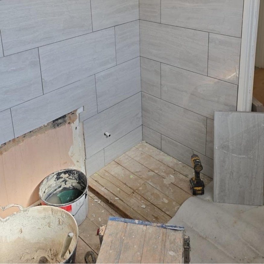 Image 6 (During)
Tiling completed across corner walls, forming a sleek grey backdrop ready for final bathroom assembly.