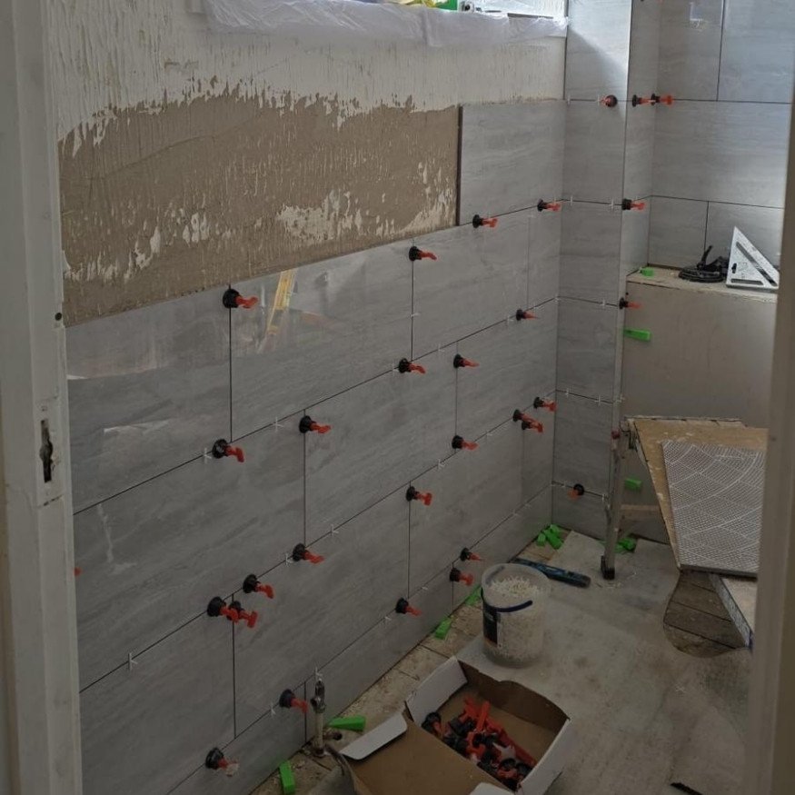 Image 3 (During)
Wall tiling underway as part of this Bathroom Renovation in Corby, using large grey tiles to modernise the space.
