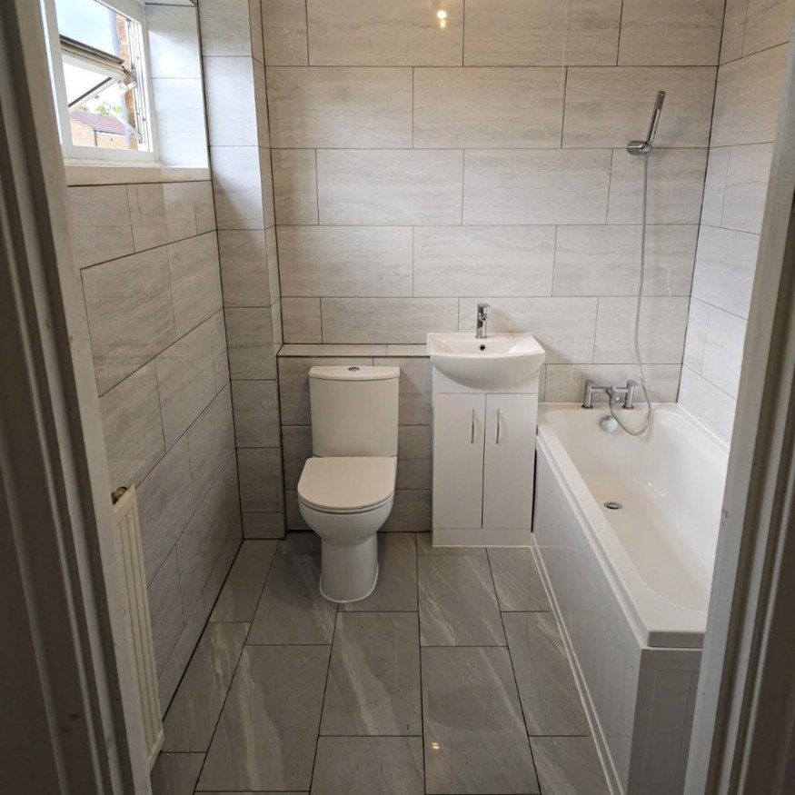Image 8 (After Completion)
A fresh, fully updated suite featuring new sanitaryware, modern tiling, and a sleek white finish – the final result of a successful Bathroom Renovation in Corby.