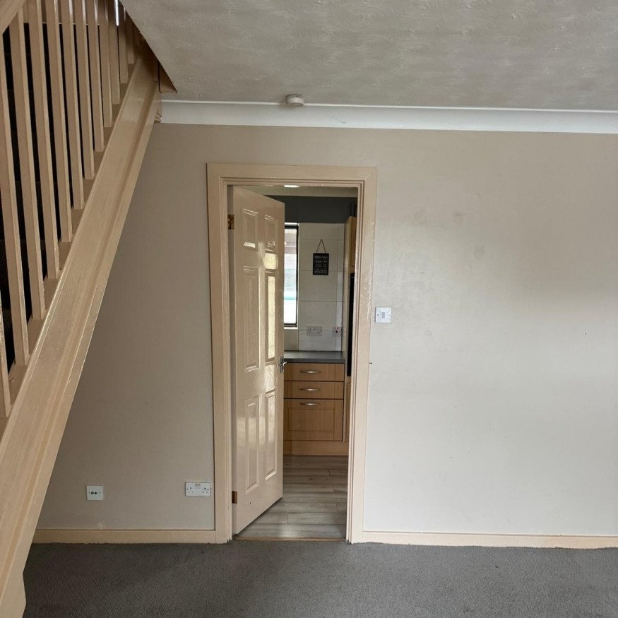 Living room walls showing signs of wear
The entrance area presented with marked walls, dated trim, and fading carpets ahead of the refurbishment.