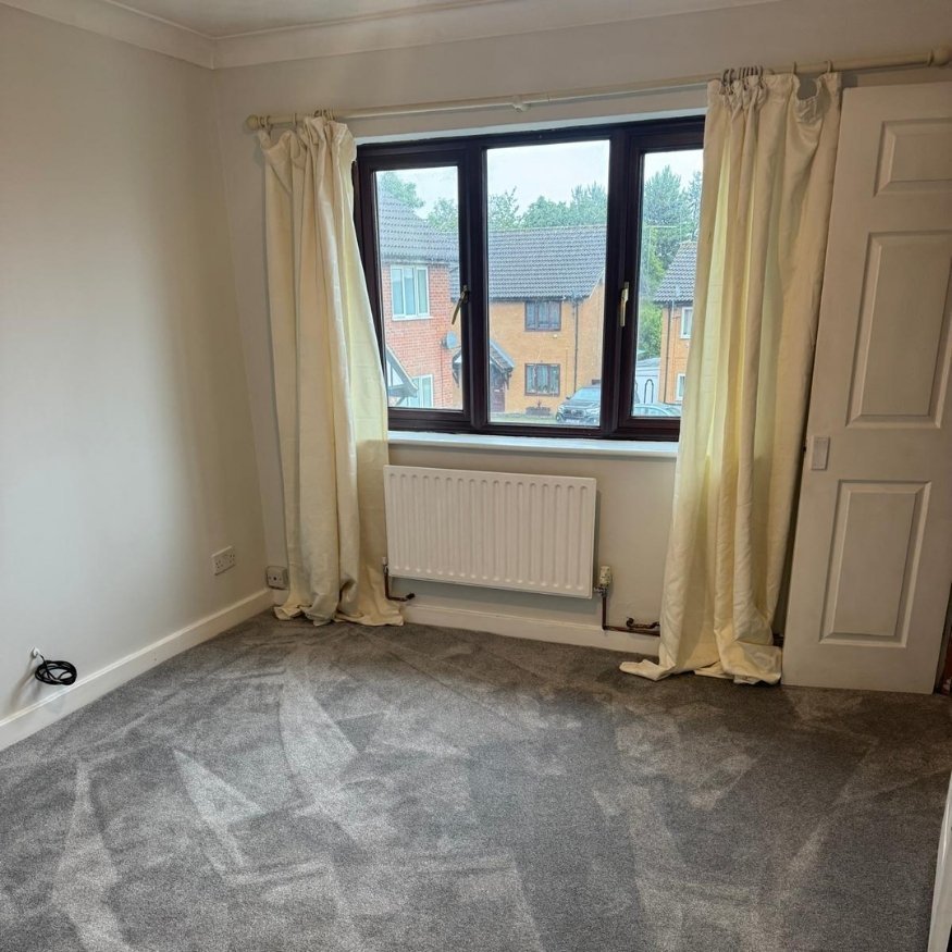 Living area rejuvenated with soft grey carpet, clean skirting boards, and a complete repaint—ideal for new tenants or buyers.