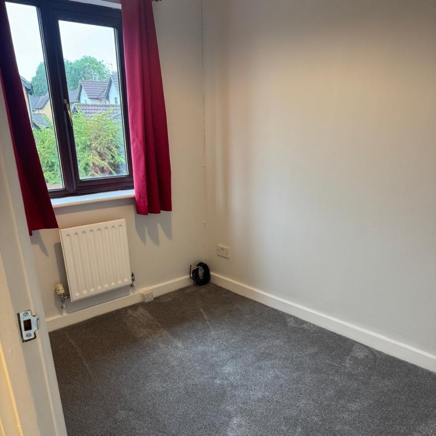 Compact bedroom repainted in soft white tones with new flooring and curtains installed to brighten the space.