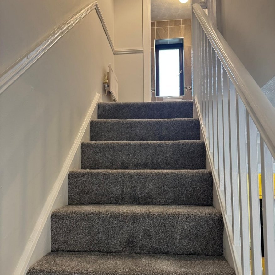 Upper stairwell detail showing the clean lines and high-quality paint finish achieved as part of the full property refurbishment in Wellingborough.