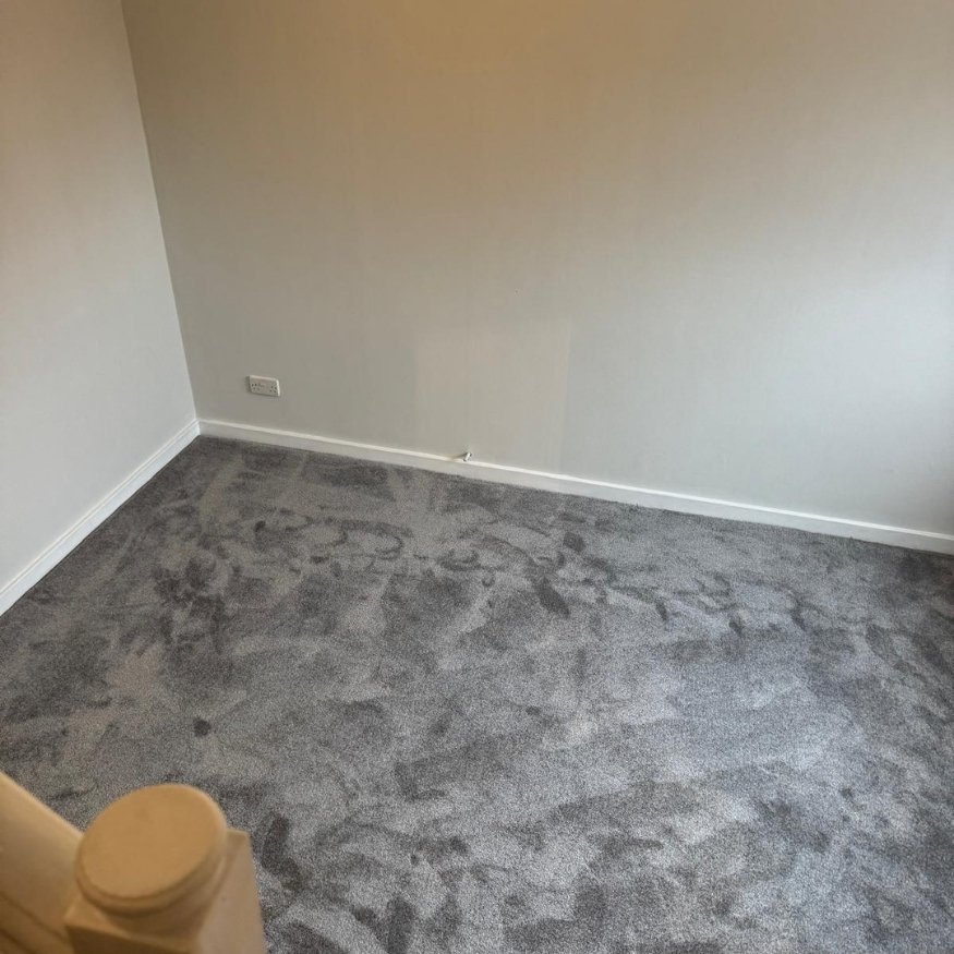 Landing area featuring brand-new carpeting and a smooth white repaint for a refreshed, modern look.