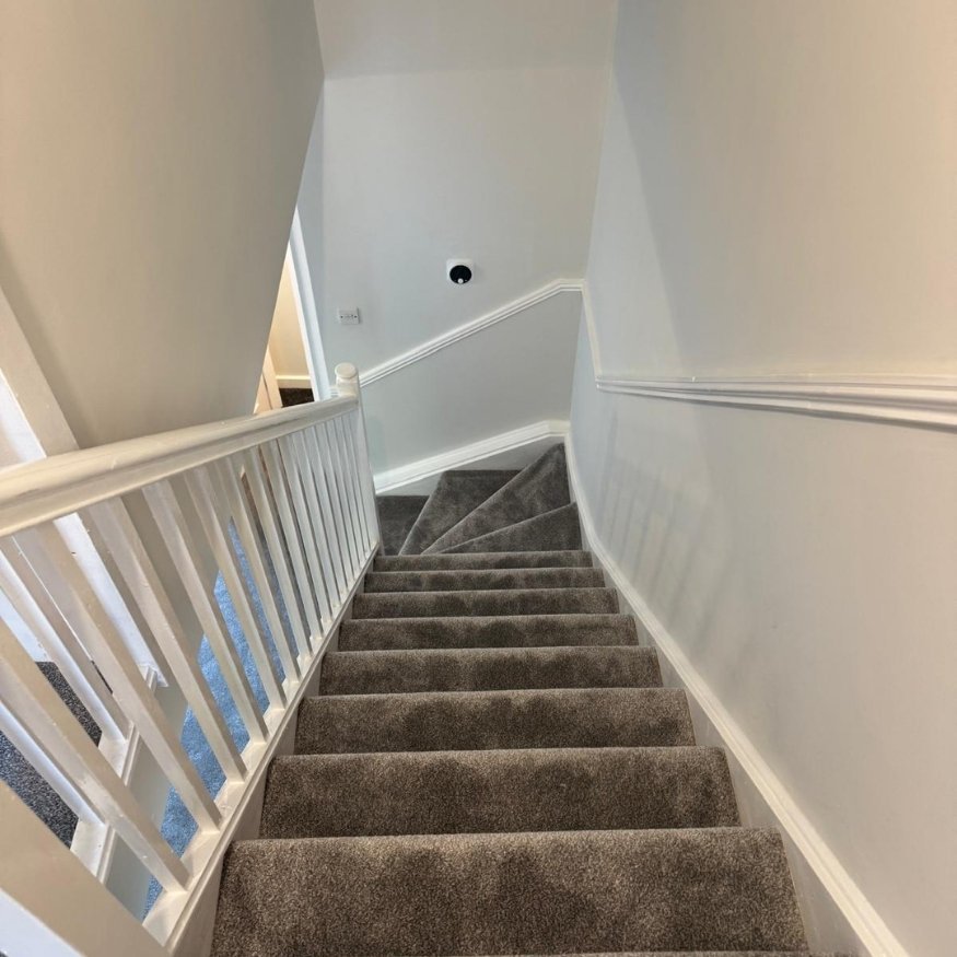 Upper stairwell detail showing the clean lines and high-quality paint finish achieved as part of the full property refurbishment in Wellingborough.