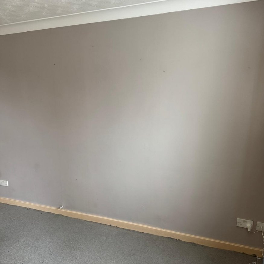 Discoloured living room space with tired decor. Faded paint and heavily used carpet signalled the need for a complete full property refurbishment in Wellingborough.